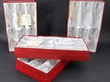 two red boxes with silverware in them on a black background