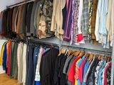 a rack of clothes in a clothing store with clothes hanging on it