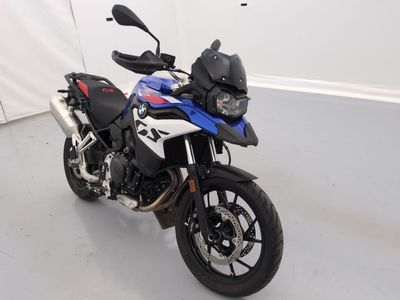 une moto bleue et blanche garée dans une pièce blanche