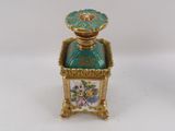 an image of a small gold and green box with flowers on it