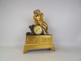 a gold clock with a statue on top of it