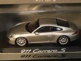 a silver toy car in a box on a table