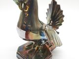 statue d'un oiseau posée sur un socle, sur fond blanc