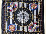 a close up of a square scarf with a compass on it