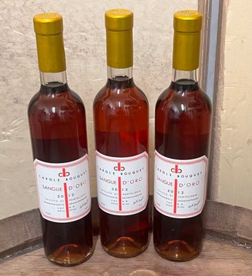 trois bouteilles de vin posées sur un tonneau, près d'un mur
