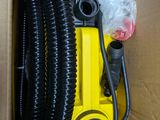a box with a yellow pump and a black hose in it