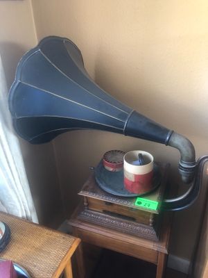 une petite table sur laquelle se trouvent un tourne-disque et une tasse