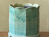 a green vase that is sitting on a table