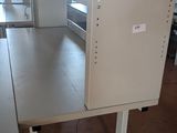 une photo d'un espace de laboratoire avec une table et des armoires