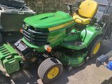 une tondeuse à gazon verte garée sur un parking