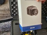 a person holding a box with a camera inside of it
