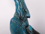 a blue bird statue sitting on top of a table