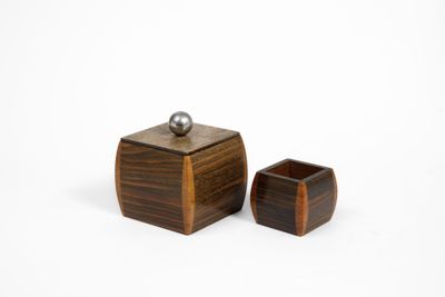 deux boîtes en bois sur lesquelles repose une balle, posées sur une surface blanche