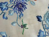 an image of a close up of a table cloth with blue flowers on it