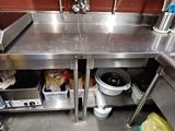 une grande cuisine en inox équipée d'un évier et d'une cuisinière