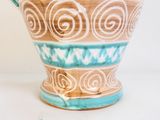 un vase bleu et blanc posé sur une table blanche