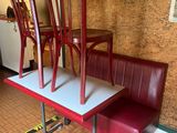 three red chairs and a table in the corner of a restaurant