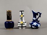 three small vases sitting next to each other on a table