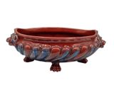 a red and blue bowl on a stand on a white background