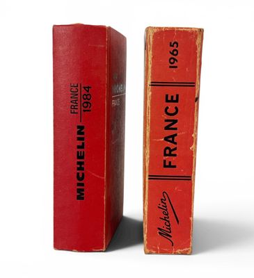 deux livres rouges portant des inscriptions noires, posés l'un à côté de l'autre