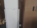 un réfrigérateur blanc posé à côté d'une pile de cartons