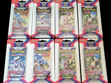 six paquets de cartes à collectionner Pokémon dans un emballage sur fond noir