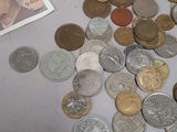 a pile of coins on a table next to a bank note