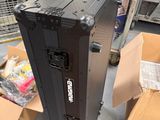 a black case sitting on the floor next to a pile of boxes