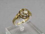 a close up of a gold ring with a diamond in the center