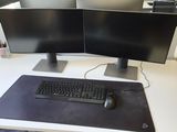 two computer monitors on a desk with a keyboard and mouse
