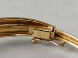 an image of a close up of a gold bracelet on a white surface