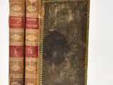 deux vieux livres posés l'un sur l'autre sur une surface blanche