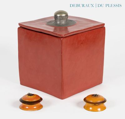 une image représentant une boîte rouge munie d'un couvercle en métal et de deux poignées en bois