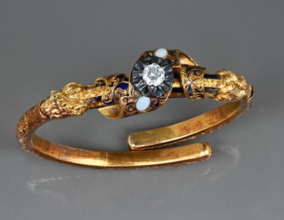 une image représentant une bague en or sertie d'un diamant noir et de saphirs bleus