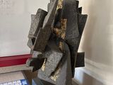 une sculpture posée sur une table devant un tableau blanc