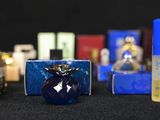 many different types of perfume bottles on a black surface