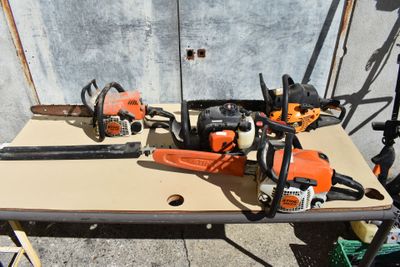 several chainsaws are sitting on a table next to a wall