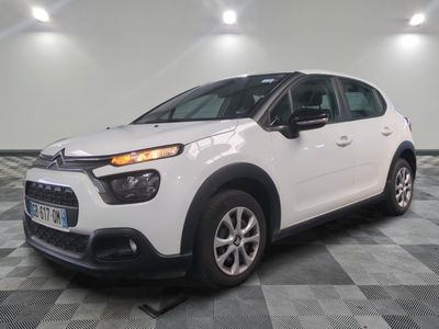 une citrole blanche garee sur un plancher en damier dans un garage