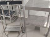 une table en acier inoxydable avec une chaise en métal à côté