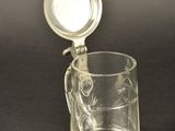 a glass pitcher with a lid and a spoon in it