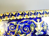 un gros plan d'un vase bleu orné de motifs dorés