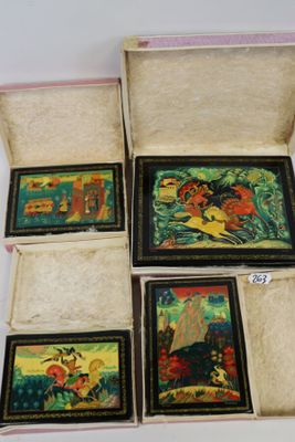 quatre petits tableaux dans un coffret posé sur une surface blanche