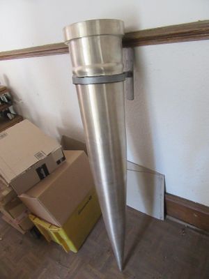 un grand objet métallique posé par terre à côté d'une boîte en carton
