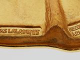 a picture of a gold plate with a shell on it