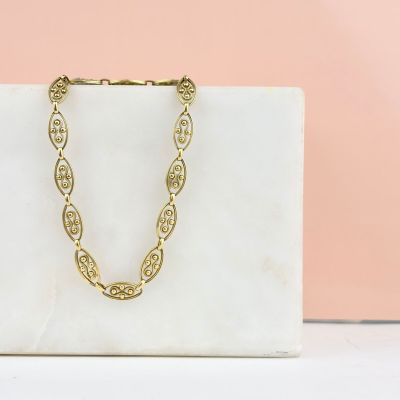 a close up of a white bag with a gold chain on it