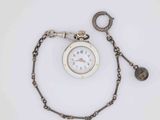 a pocket watch with a chain around it on a white surface