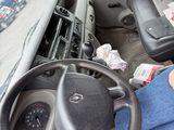 a man sitting in the driver ' s seat of a bus