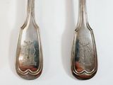 pair of silverware spoons on a white surface with a picture of a man and a woman on them