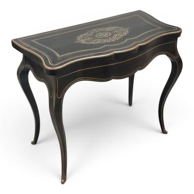 a small black table with a gold decoration on the top