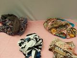 many different types of hats and scarves on a table